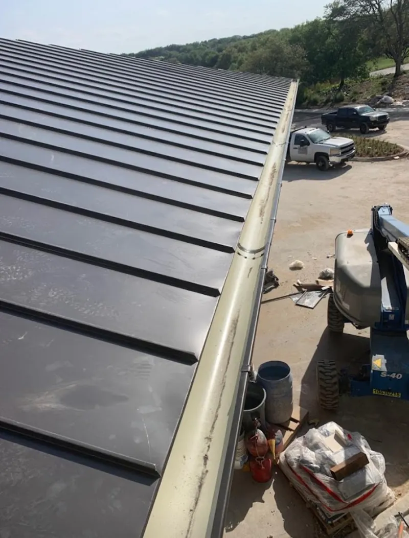 Standing seam panel and gutter detail on a metal roofing jobsite in Star